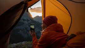 Frau im Zelt fotografiert mit Smartphone