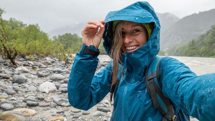 Frau mit Regenjacke beim Wandern